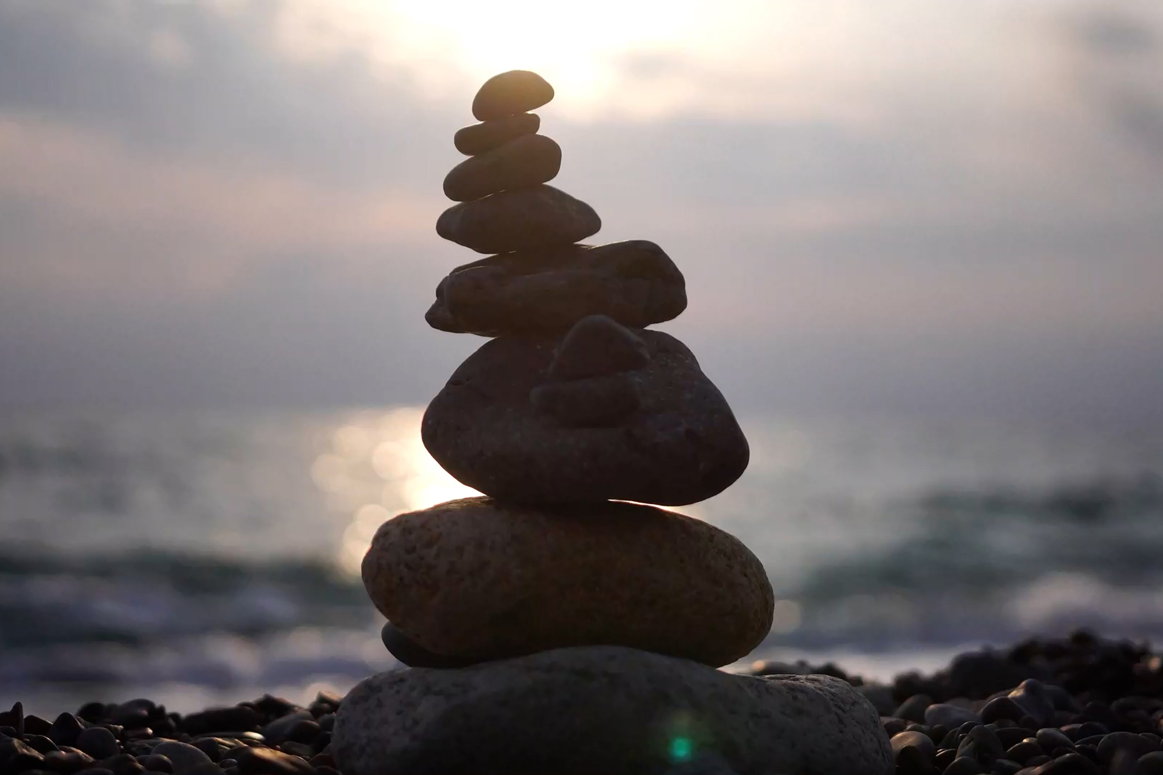 Balanced pebbles pyramid on the beach on cloudy day