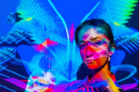 Colorful portrait of woman with projector multicolor light illumination