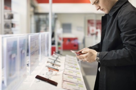 Man testing a cellphone in a digital store